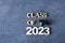 Class of 2023 concept. Wooden number 2023 with graduated cap on dark concrete background with tinsel