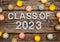 Class of 2023 on paper card with LED cotton balls top view on wooden background