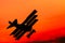 Classic airplane flying on a red sky in the evening light