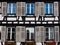 Classic Alsatian windows in a half-timbered house, decorated with wooden carvings and flowers