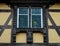 Classic Alsatian windows in a half-timbered house, decorated with wooden carvings and flowers