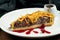 Classic American piece of beef pie with cheddar, cranberry sause and brisket beef on a white plate in a composition with