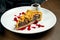 Classic American piece of beef pie with cheddar, cranberry sause and brisket beef on a white plate in a composition with