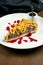 Classic American piece of beef pie with cheddar, cranberry sause and brisket beef on a white plate in a composition with