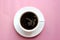Classic Americano coffee in a small white ceramic Cup on a pink bright background. Top view