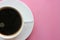 Classic Americano coffee in a small white ceramic Cup on a pink bright background. Top view