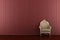 Classic armchair in front of red striped wall