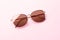 Classic aviator mirrored flat lens sunglasses with golden metal frame closeup on pink background