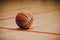 Classic Basketball on Wooden Court Floor Close Up with Blurred Arena in Background