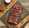 Classic beef steak uncooked meat ,fried outside, red inside, with red juice, cut into pieces on a wooden board