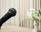 Classic Black Microphone on Beautiful Stage with Brown Curtain and Big Vintage Style Flowerpot in The Corner