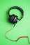 Classic black wired headphones on green background