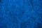 Classic Blue background made of textured plywood sheet with fragments of compressed sawdust. Color of the year 2020 - trendy