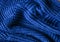 Classic blue dark knitted background. Close up texture . wrinkled and shadows, top view. 2020 trend color