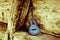 A classic blue guitar leaning against an old stable