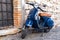 Classic blue Vespa PX 150 scooter stands parked