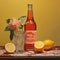 Classic Bottle Of Lemonade With Bronze Drawing On Coral Background