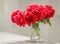 Classic bouquet of red peonies in a glass vase indoors, home decor