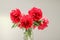 Classic bouquet of red peonies in a glass vase indoors, home decor