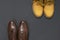 Classic brown leather men`s shoes and Yellow men`s work boots from natural nubuck on gray black background top view flat lay cop
