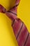 Classic brown striped tie knot close up on yellow background