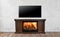 Classic burning fireplace with TV in bright empty living room interior of house