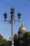 Classic candelabra street light with five lamps. Saint Isaac`s Cathedral`s golden cupola in background