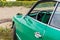 Classic car chrome mirror. Volksvagen Karmann Ghia Coupe, green retro car on sunflower field. Italian classic car -