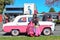 Classic car, woman, and girl, all in bright pink