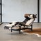 Classic chaise-longue chair with cowhide leather design, in a room with white wall and cowhide rug. Generative AI