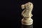 Classic Chess White Knight on black surface, isolated