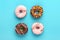 Classic chocolate, pink strawberry, decorated with colorful sprinkles donut isolated on blue background Flat lay Top View Knolling