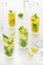 Classic cocktail mix of different lemonades , mohito in glass on white background with lime, lemon, mint, apple ,soda,  alcohol