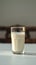 Classic composition Glass of milk, side view, on white table