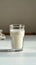 Classic composition Glass of milk, side view, on white table