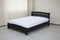 classic dark arched wooden bed with hard headboard