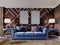 Classic designer sofa in blue with soft upholstery, two side tables with lamps. Wooden walls with gold accents. Living room in a