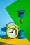 Classic desktop clock, Hourglass colored background on yellow, green and blue, copy space