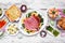 Classic Easter ham dinner. Top down view table scene on a white wood background.