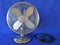 Classic Electric Table Fan. Chrome, retro,  front view, closeup, isolated against blue background.