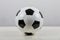Classic football ball on the table, black and white typical hexagon pattern, isolated on  grey background. Real, traditional