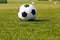 Classic football soccer ball on grass field. Side view on retro classic football ball