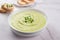 Classic french chilled cream soup vichyssoise - warm or cold potato leek soup topped with microgreens in white bowl on