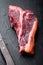 Classic fresh beef striploin steaks,T bone cut, on black stone background