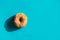 Classic fried sugared donut on bright blue background