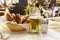 Classic German dinner of fried sausages with braised cabbage on large white plates with light beer, standing on table in