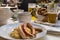 Classic German dinner of fried sausages with braised cabbage on large white plates with light beer, standing on table in