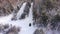 Classic gray car driving through the white winter snowy forest on country road. Top view. Winter or alpine road in the