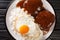 Classic Hawaiian dish, Loco Moco consists of steamed rice with juicy hamburger steak, fried egg and gravy close-up on a plate.