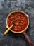 Classic homemade amatriciana tomato sauce in the cooking pan on a dark background, top view. Pasta bucatini amatriciana tomato